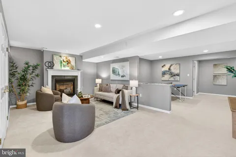 a living room with furniture a fireplace and a potted plant