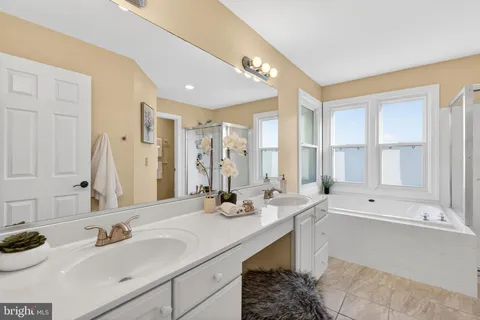 a bathroom with a tub sink and mirror