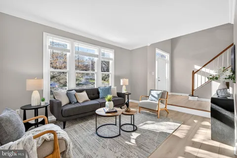 a living room with furniture potted plant and a large window