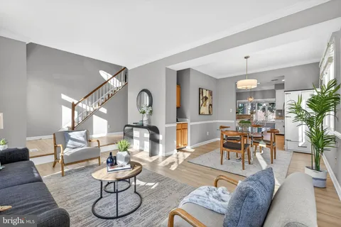 a living room with furniture and a dining table with wooden floor