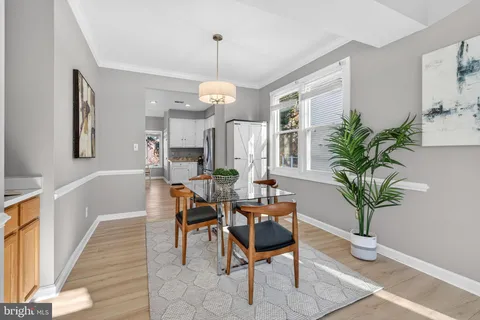 a view of a dining room with furniture a chandelier and wooden floor