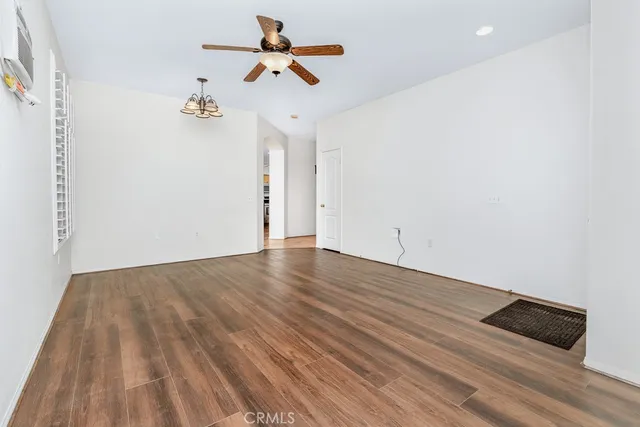 a view of a room with wooden floor and ceiling fan