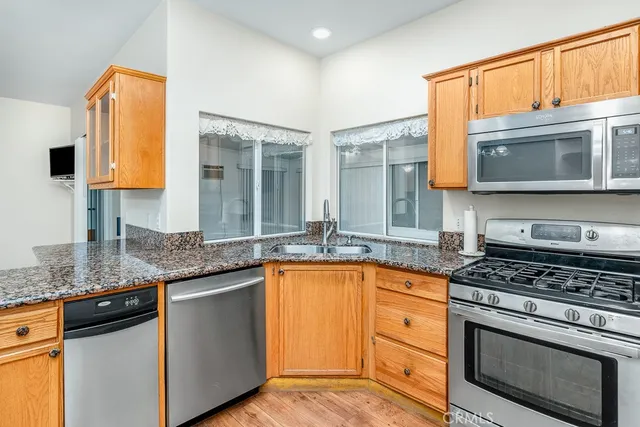 a kitchen with stainless steel appliances granite countertop a stove a sink and a microwave