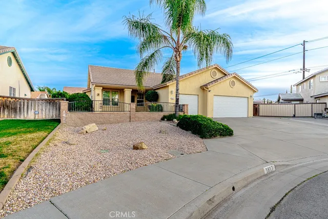 a view of a house with a yard and palm trees