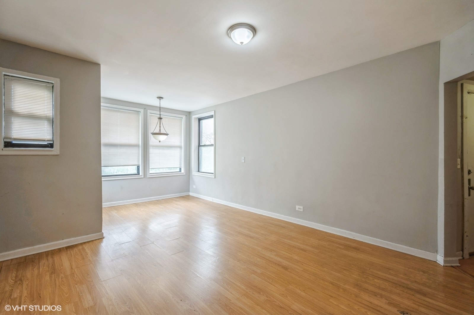 6007 South Michigan Avenue, Unit 3 Chicago, IL 60637 - Photo 3 of 9 a view of an empty room with wooden floor and a window