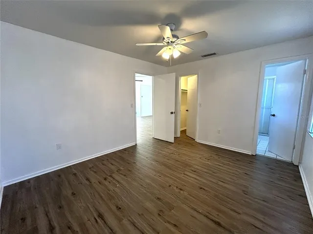 a view of an empty room with wooden floor