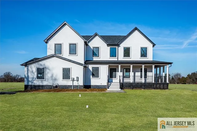 a front view of a house with a yard and trees