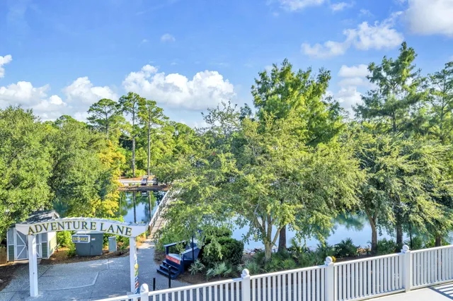 a bedroom with a bed a dresser and a chandelier
