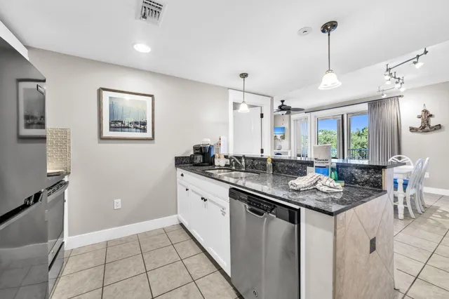 a kitchen with granite countertop white cabinets and stainless steel appliances