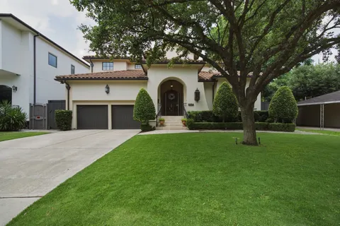 a front view of a house with garden and trees