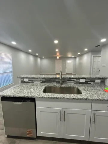 a kitchen with a sink a counter top stainless steel appliances and cabinets