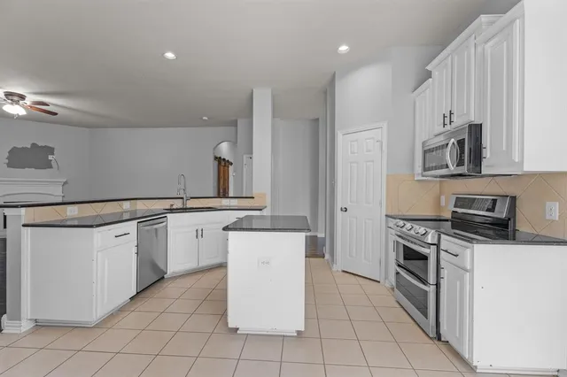 a kitchen with granite countertop cabinets stainless steel appliances and a sink