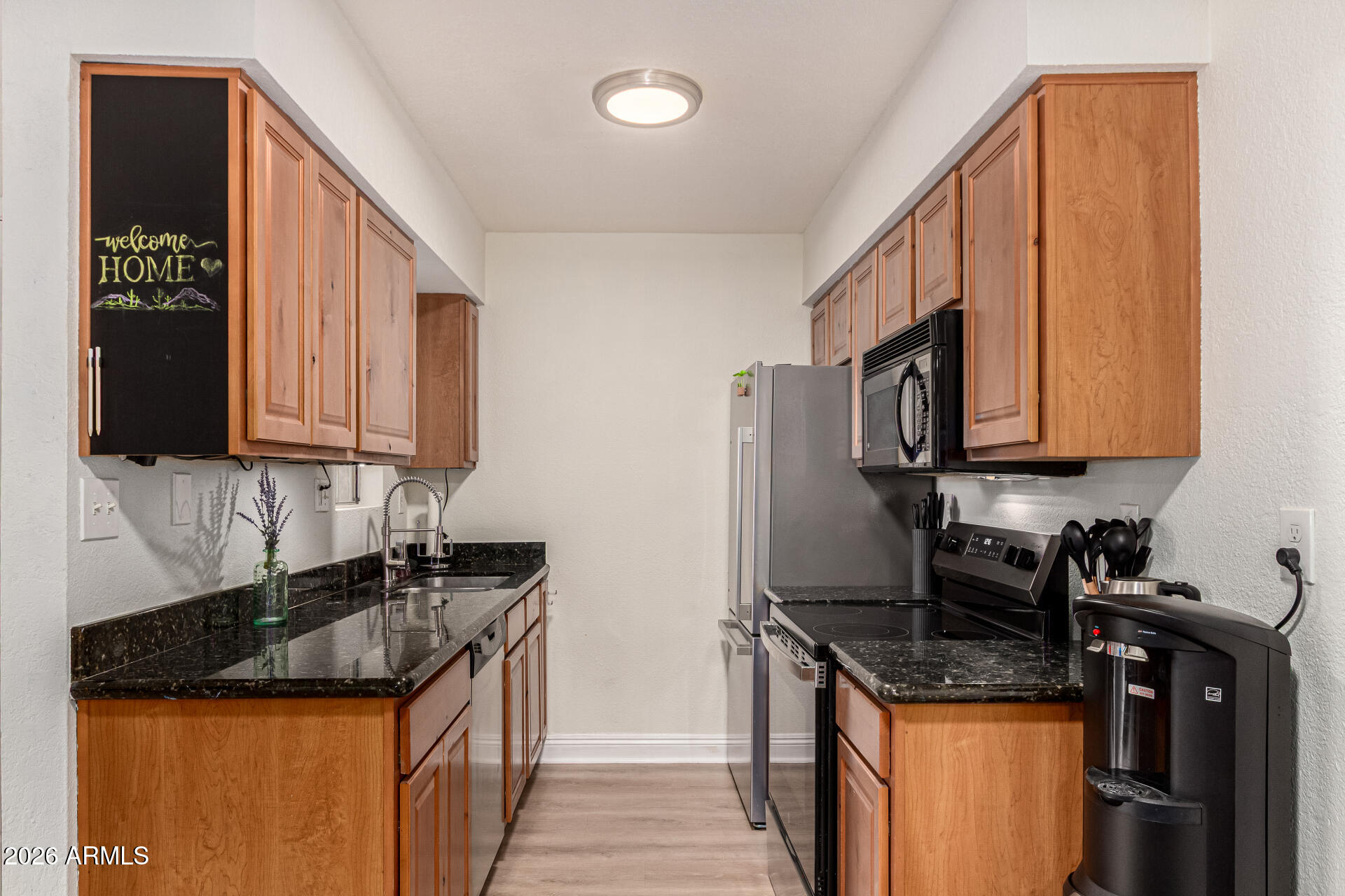 5877 North Granite Reef Road, Unit 1133 Scottsdale, AZ 85250 - Photo 13 of 33 a kitchen with stainless steel appliances granite countertop a stove a sink and a microwave