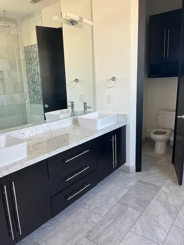 a bathroom with a double vanity sink toilet and mirror