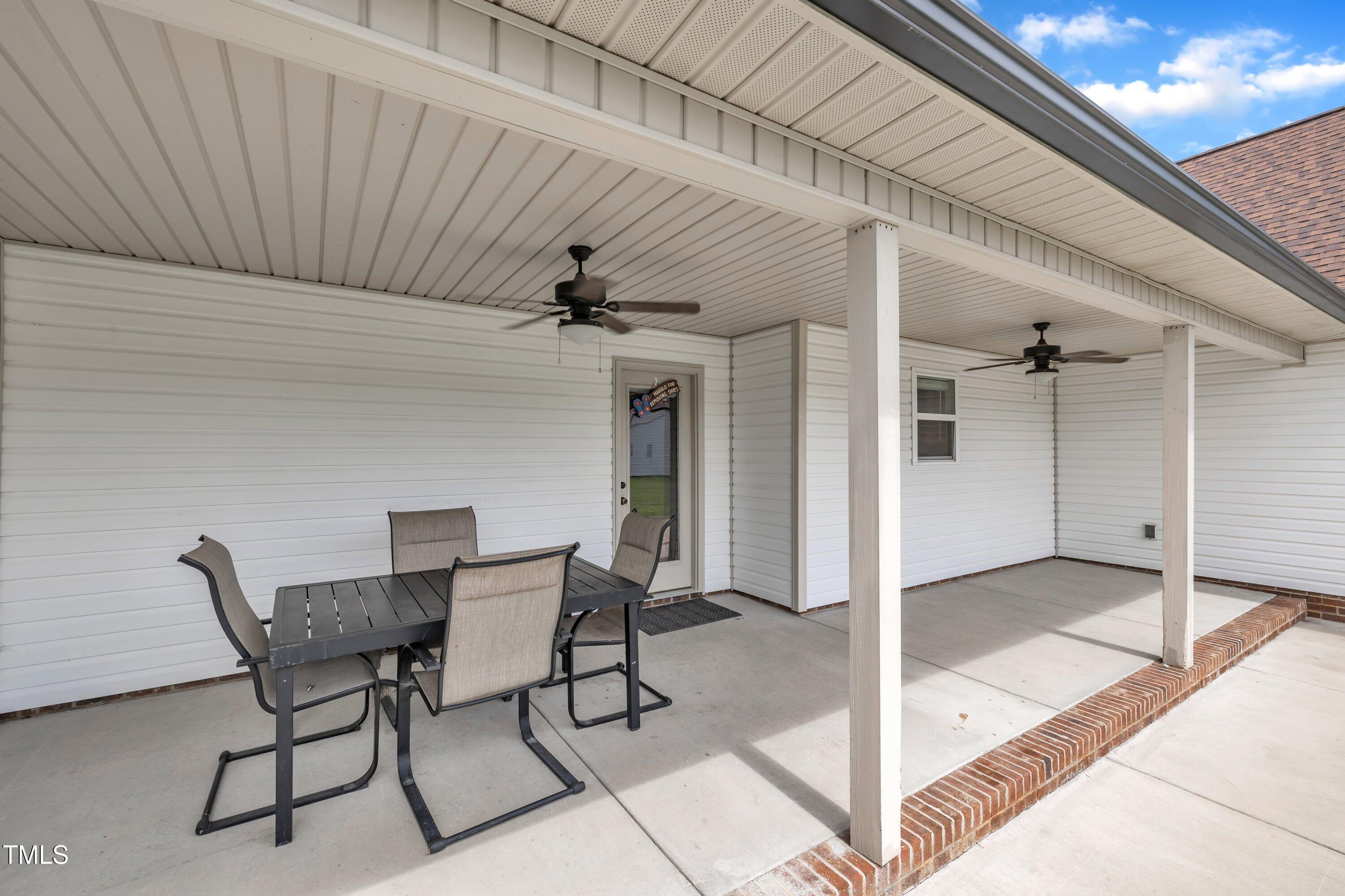 1149 Surles Road Benson, NC 27504 - Photo 5 of 29 a patio with a table and chairs and potted plants