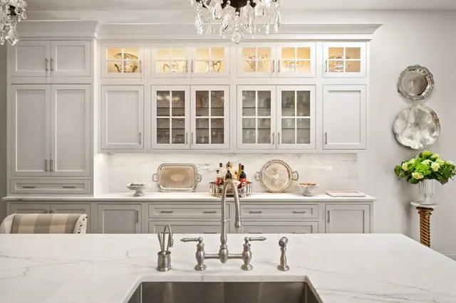 a kitchen with granite countertop a sink and a white wooden cabinets