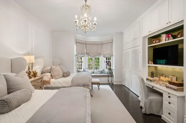 a living room with furniture a chandelier and a flat screen tv