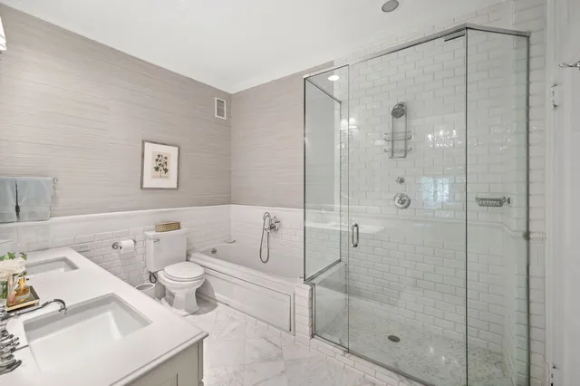 a bathroom with a shower sink vanity mirror and toilet