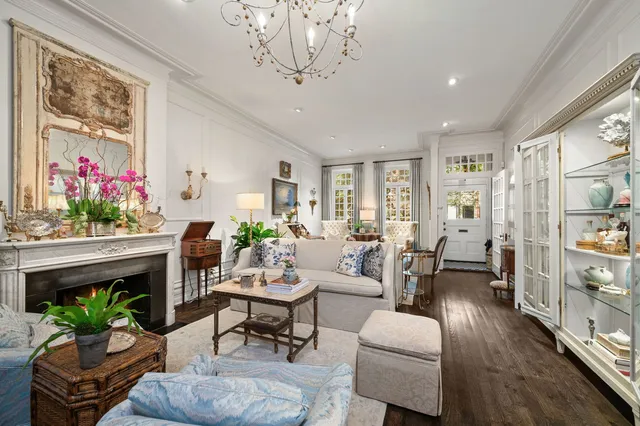 a living room with furniture a chandelier and a fireplace