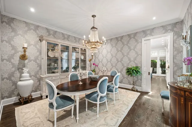 a dining room with furniture a chandelier and wooden floor