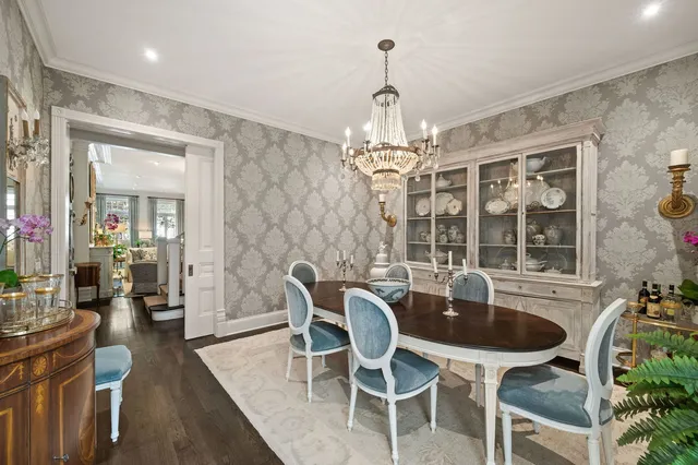 a dining room with furniture a chandelier and wooden floor