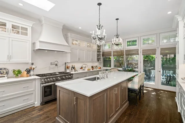 a kitchen with a stove a sink a chimney and a large window