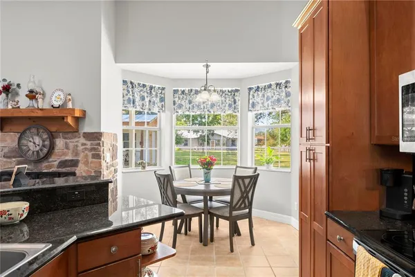 a dining room with wooden floor furniture and a chandelier