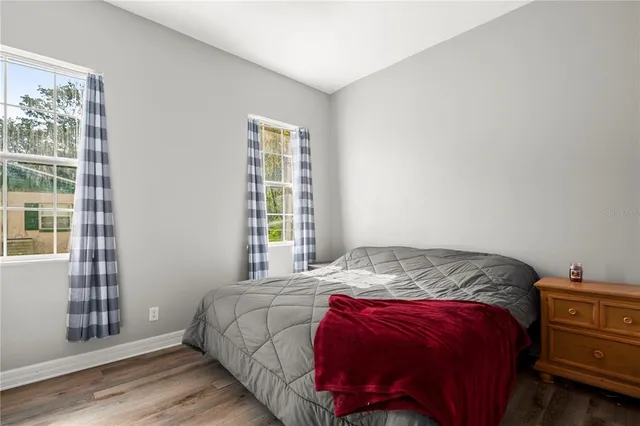 a bedroom with a bed and wooden floor