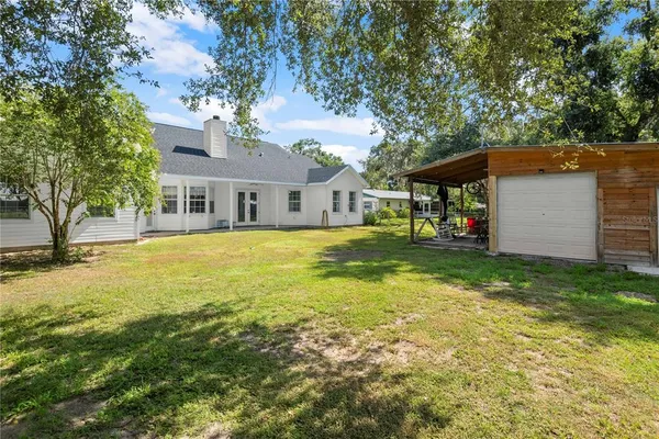 a view of a house with a yard and sitting area