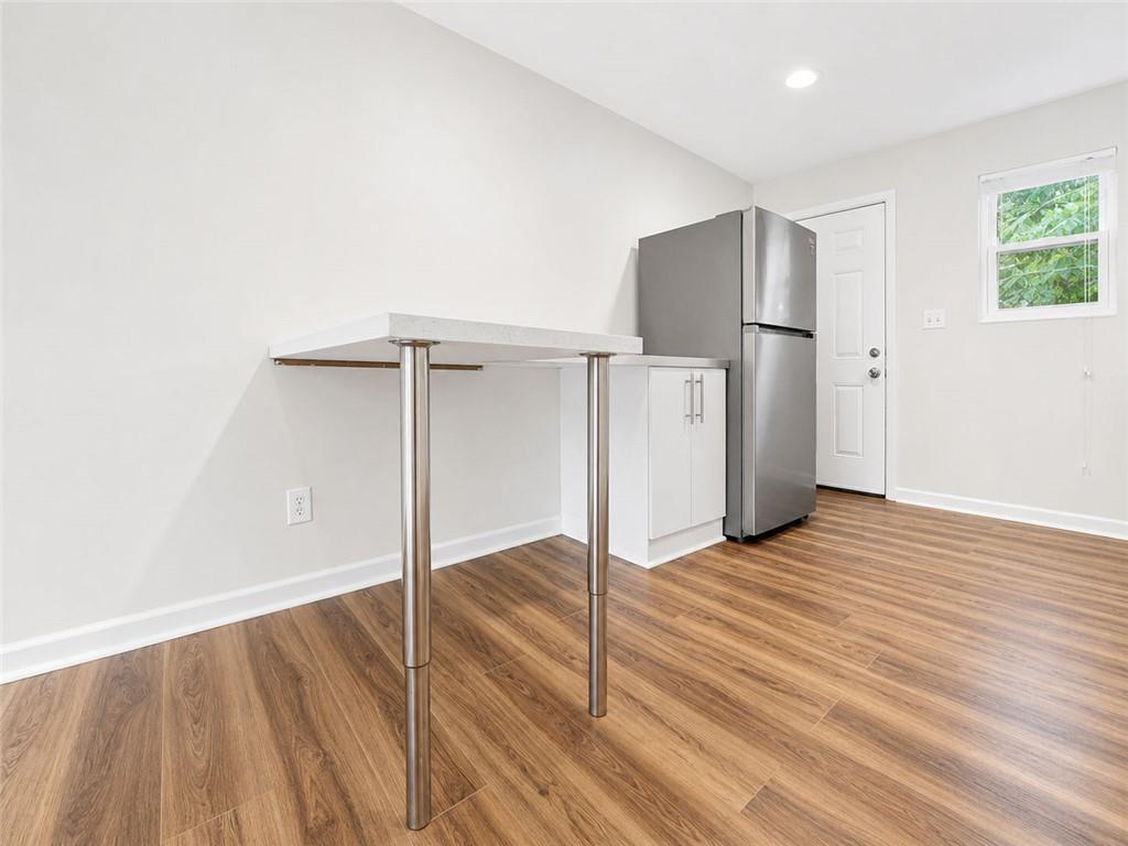 3193 East Point Street, Unit 4 Atlanta, GA 30344 - Photo 7 of 20 an empty room with wooden floor and a refrigerator