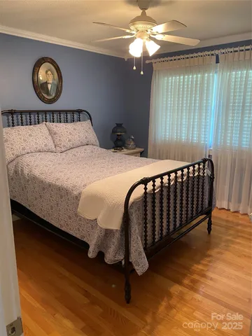 a bedroom with a large bed chandelier and a window