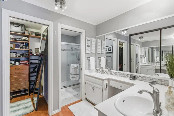 a bathroom with a double vanity sink a mirror and a shower
