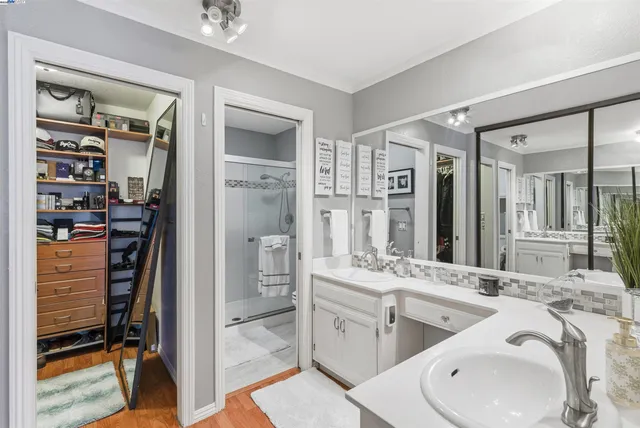 a bathroom with a double vanity sink a mirror and a shower