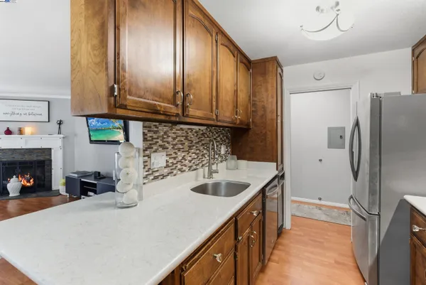 a kitchen with stainless steel appliances granite countertop a sink a refrigerator and a stove