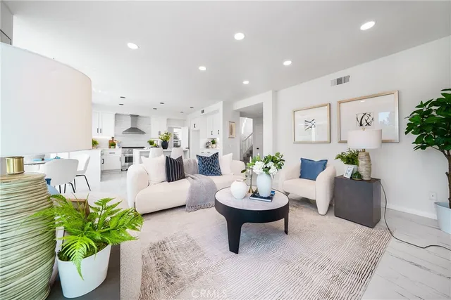 a spacious bedroom with a bed a mirror on dresser and a large window
