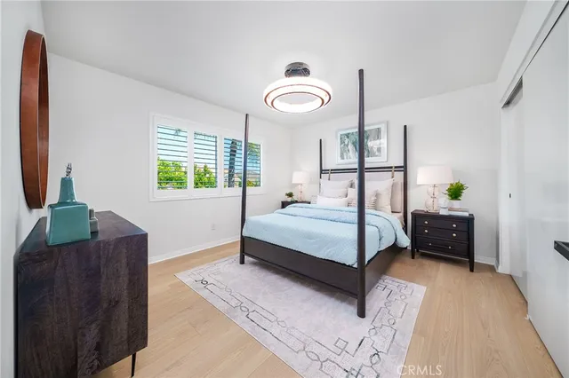 a bedroom with a large bed and a potted plant