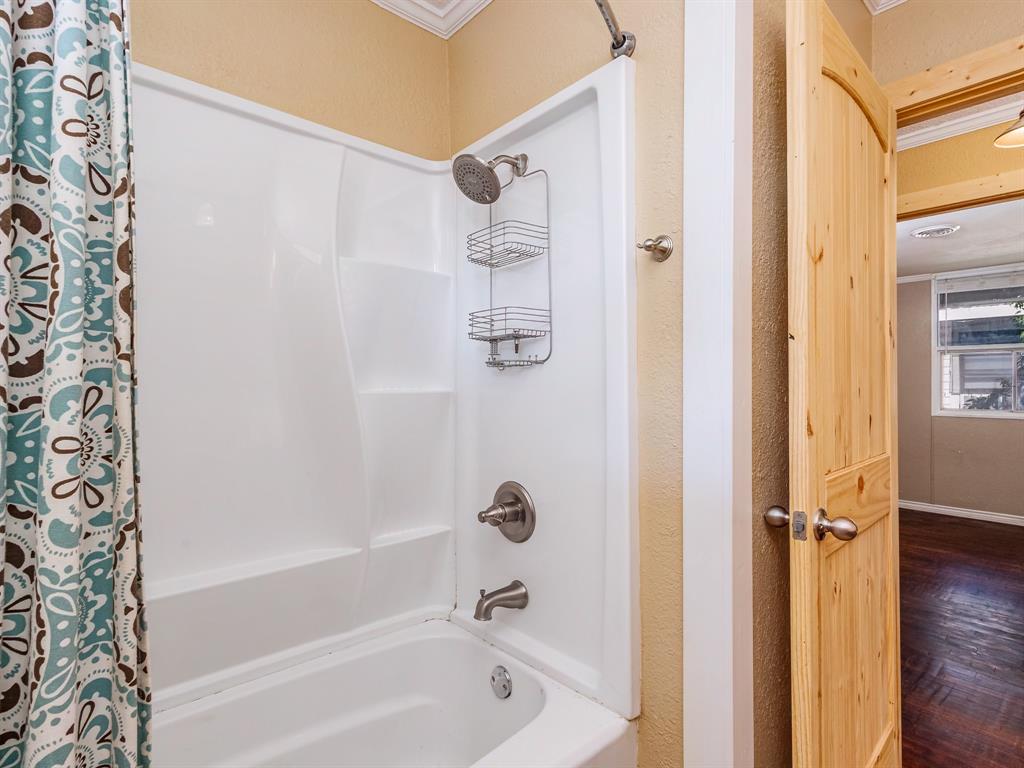 311 Miami Street Coleman, TX 76834 - Photo 15 of 31 a bathroom with a bathtub and a shower