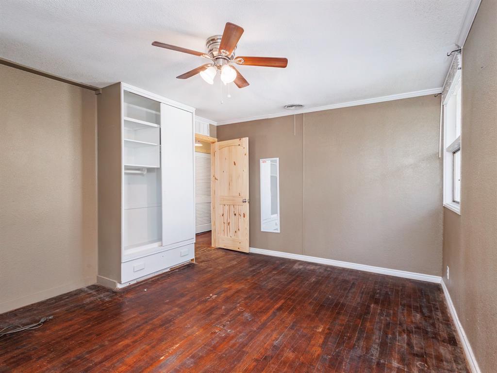 311 Miami Street Coleman, TX 76834 - Photo 22 of 31 wooden floor in an empty room with a window