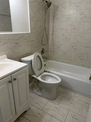 a bathroom with a granite countertop toilet a sink and bathtub