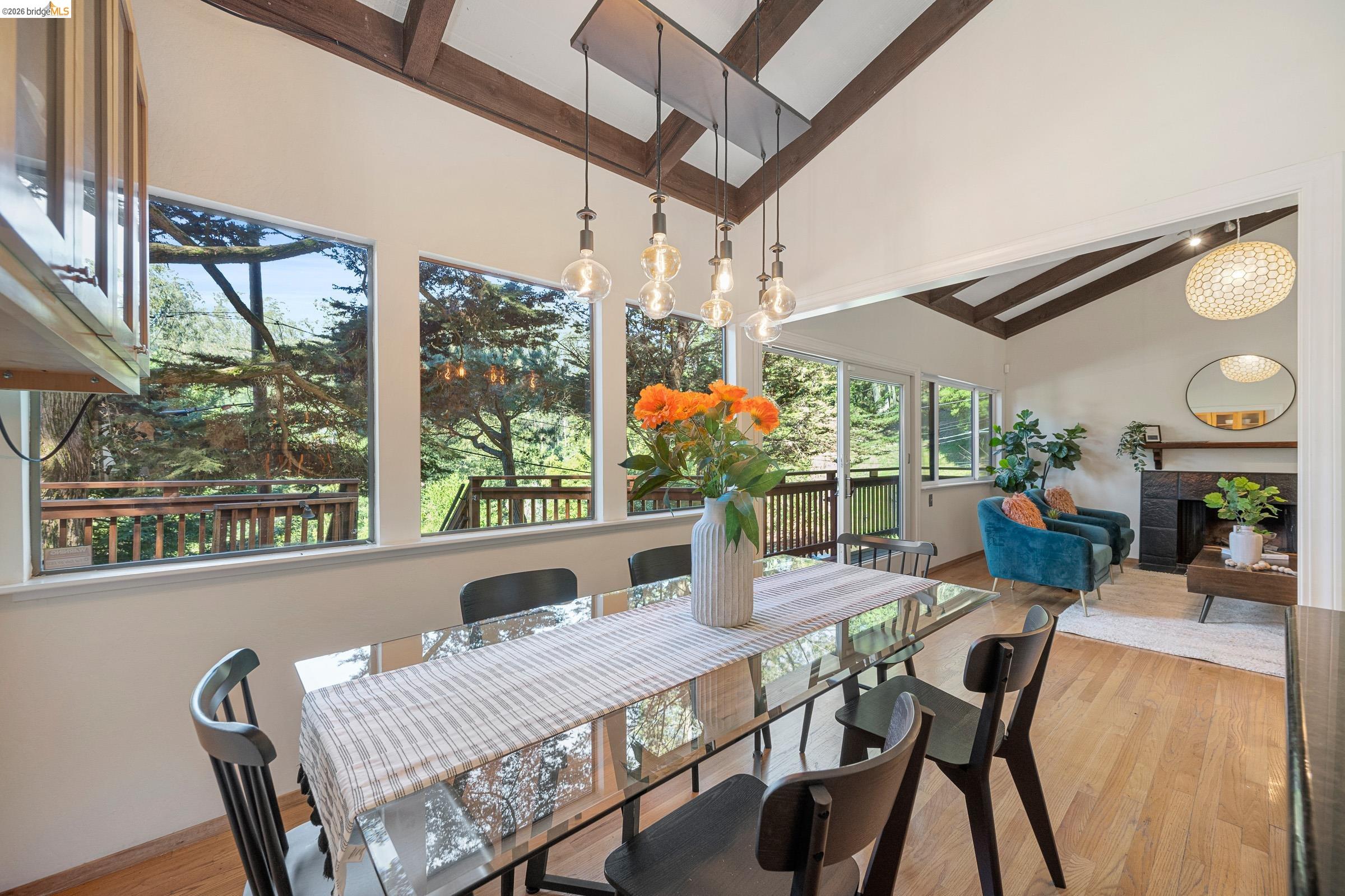 6600 Heather Ridge Way Oakland, CA 94611 - Photo 17 of 58 Dining room featuring vaulted ceiling, light wood-style floors, and a tile fireplace