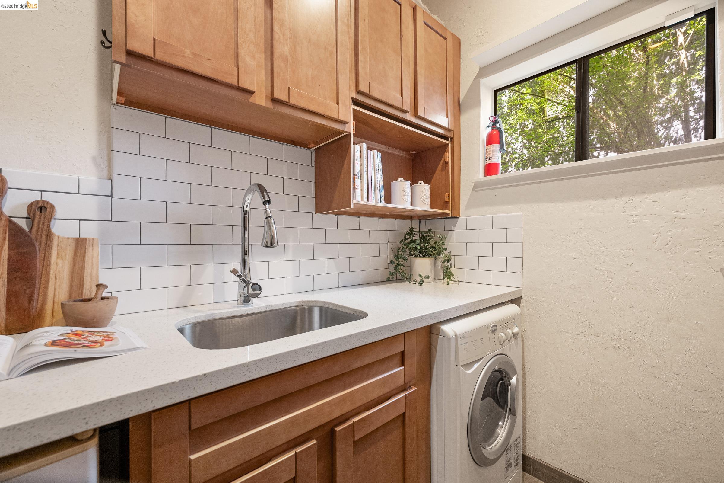 6600 Heather Ridge Way Oakland, CA 94611 - Photo 43 of 58 Laundry room with washer / clothes dryer and a textured wall