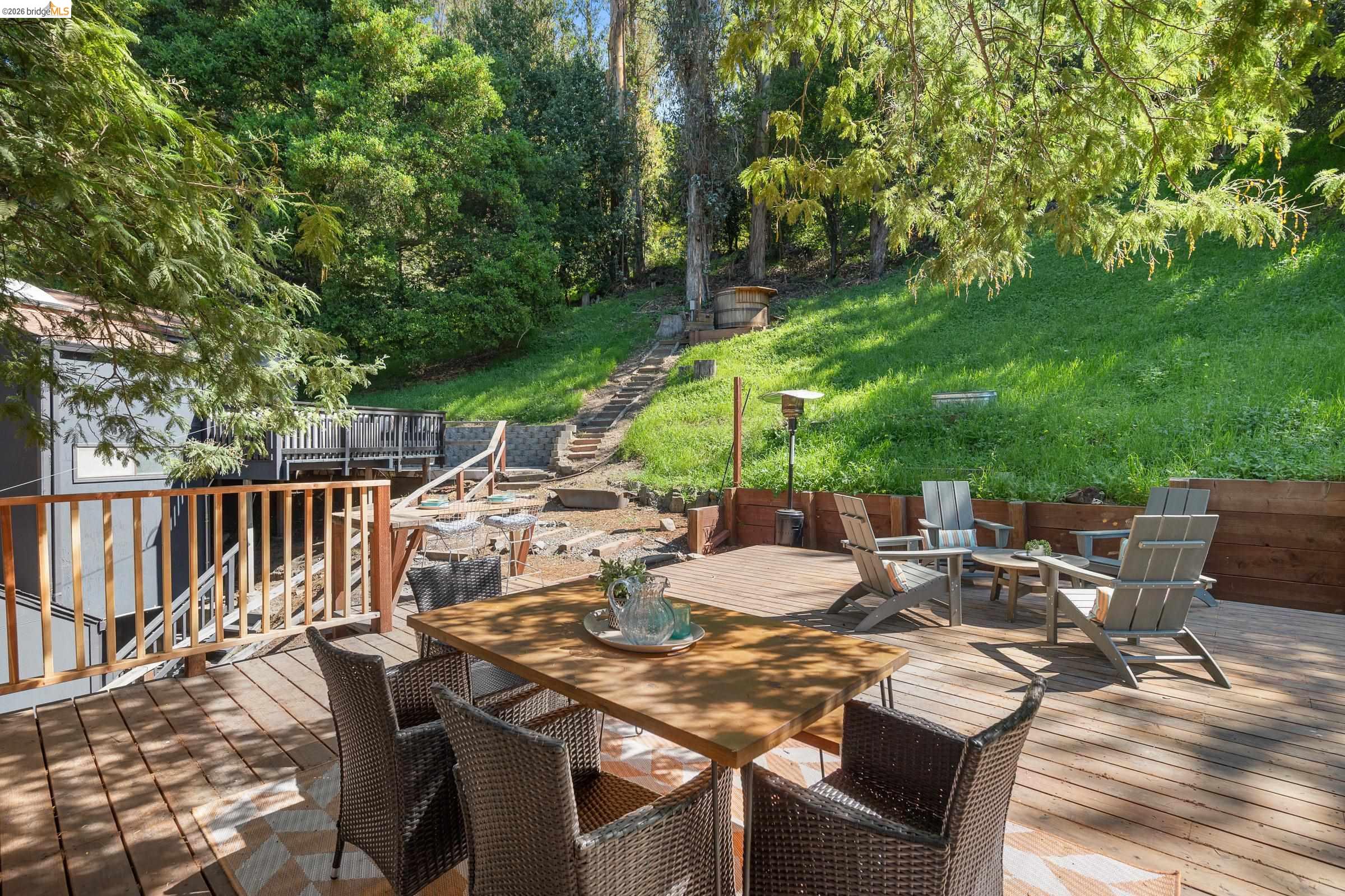 6600 Heather Ridge Way Oakland, CA 94611 - Photo 49 of 58 Deck with outdoor dining area, an outdoor fire pit, and a yard