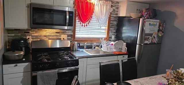 a kitchen with stainless steel appliances granite countertop a stove and a refrigerator