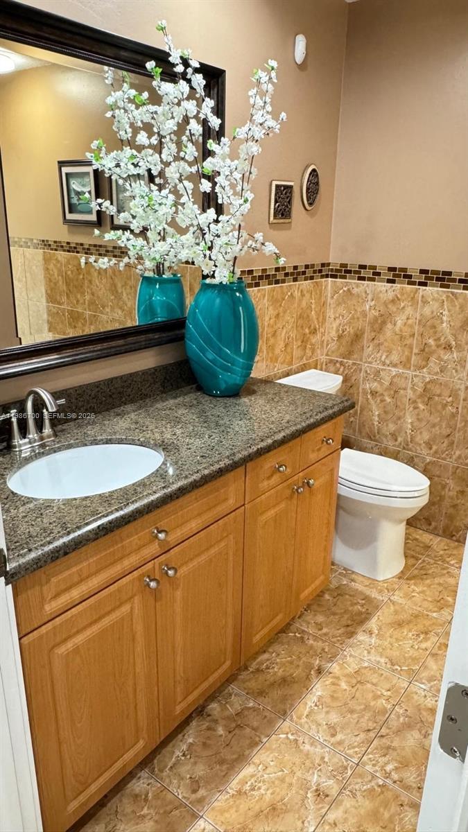 14620 Southwest 151st Terrace Miami, FL 33196 - Photo 17 of 30 a bathroom with a granite countertop sink a toilet and mirror