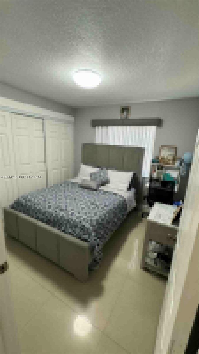 14620 Southwest 151st Terrace Miami, FL 33196 - Photo 21 of 30 a bedroom with a bed couch and a window