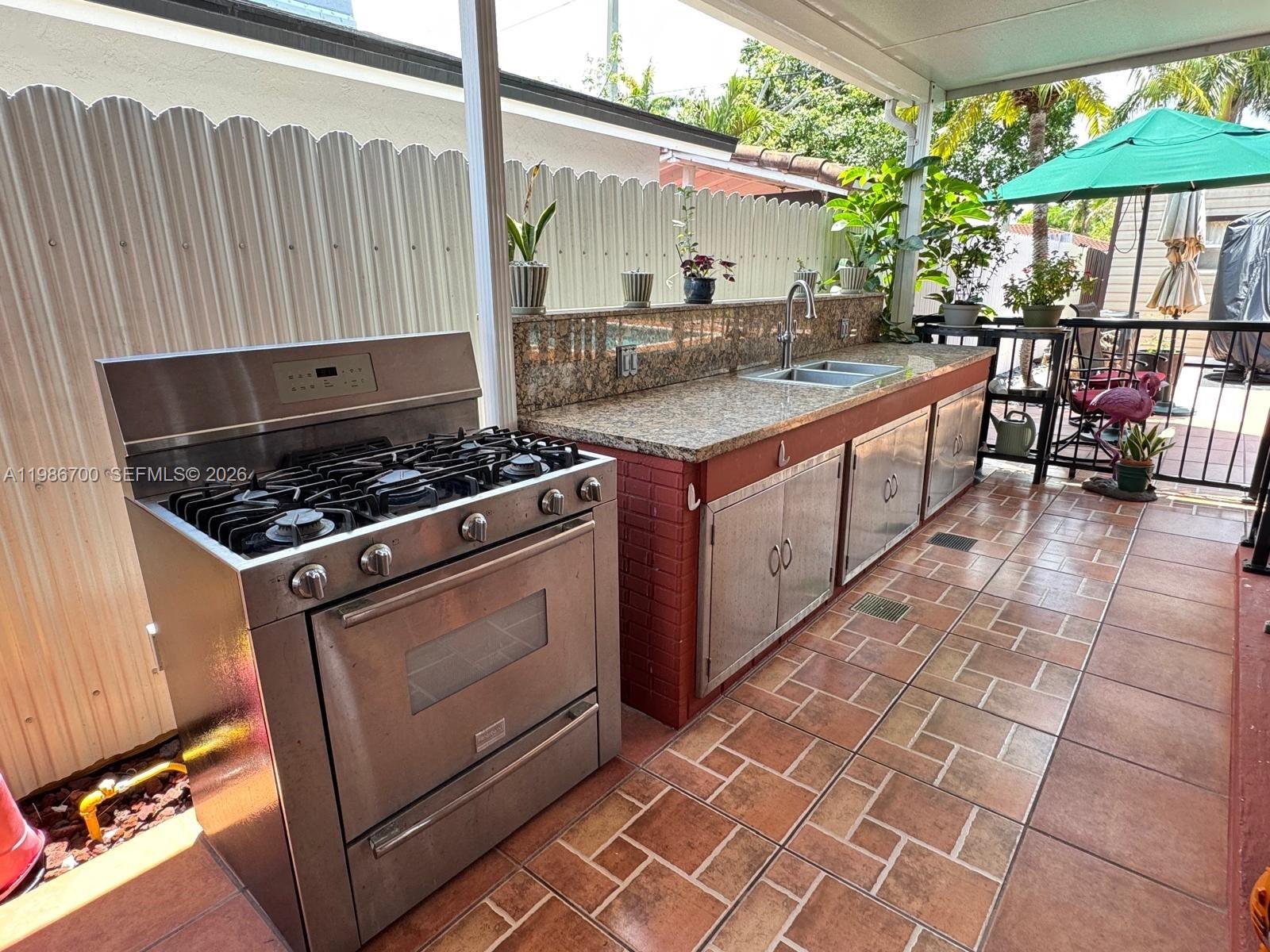 14620 Southwest 151st Terrace Miami, FL 33196 - Photo 23 of 30 a kitchen with stainless steel appliances granite countertop a stove a sink and a microwave