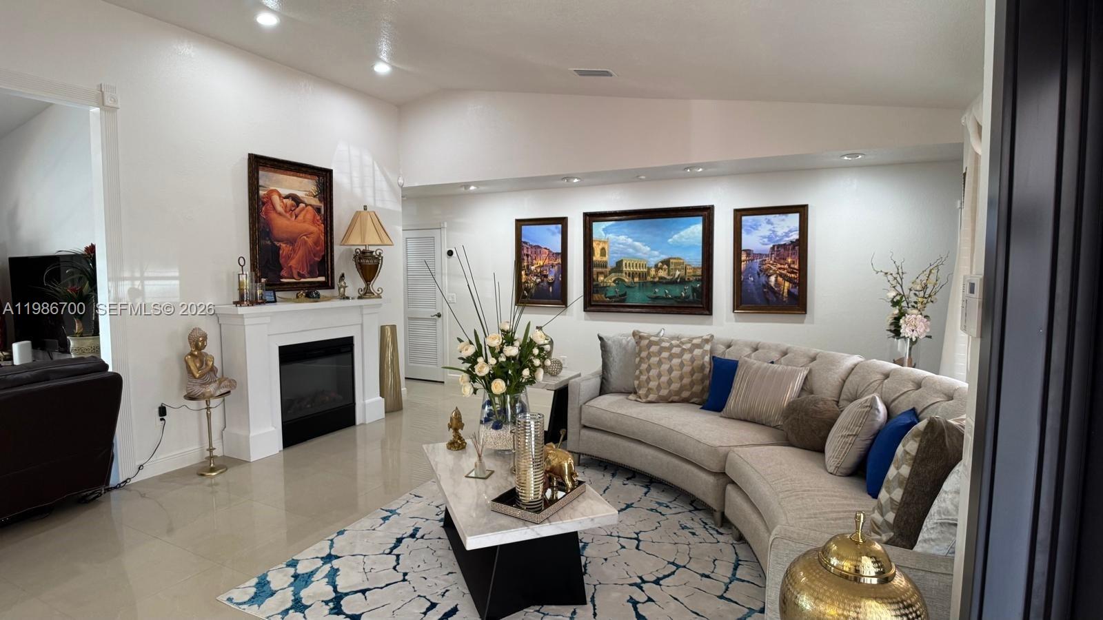 14620 Southwest 151st Terrace Miami, FL 33196 - Photo 7 of 30 a living room with furniture a fireplace and a flat screen tv