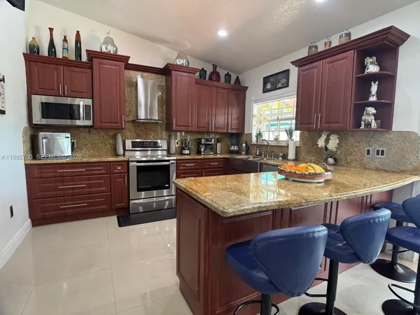 a kitchen with granite countertop wooden cabinets and stainless steel appliances