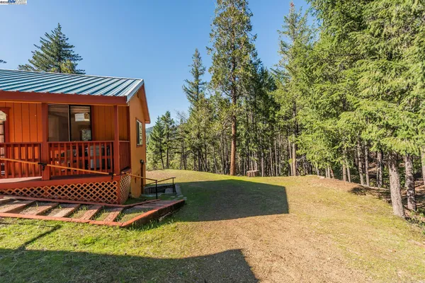 a view of a wooden deck with chairs and a yard