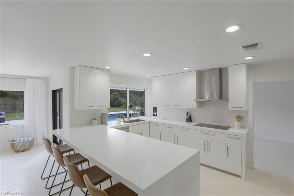 796 Ketch Drive Naples, FL 34103 - Photo 5 of 13 a kitchen with a sink a stove a refrigerator and chairs